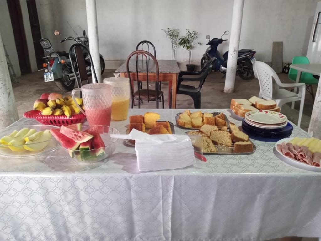 Hotel Contorno في Santa Inês: طاولة عليها قماش الطاولة البيضاء مع الطعام