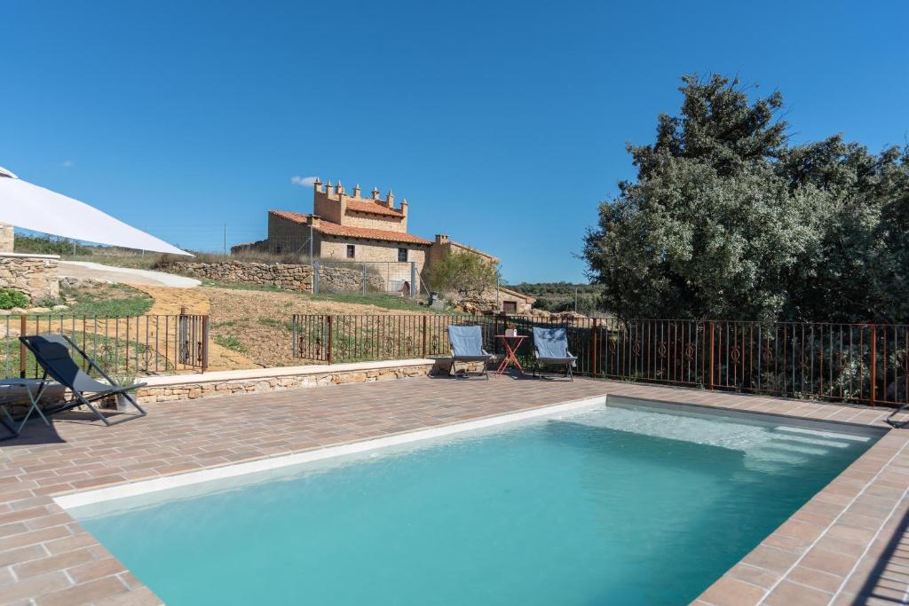 una piscina con una casa en el fondo en Torre Amador en Culla