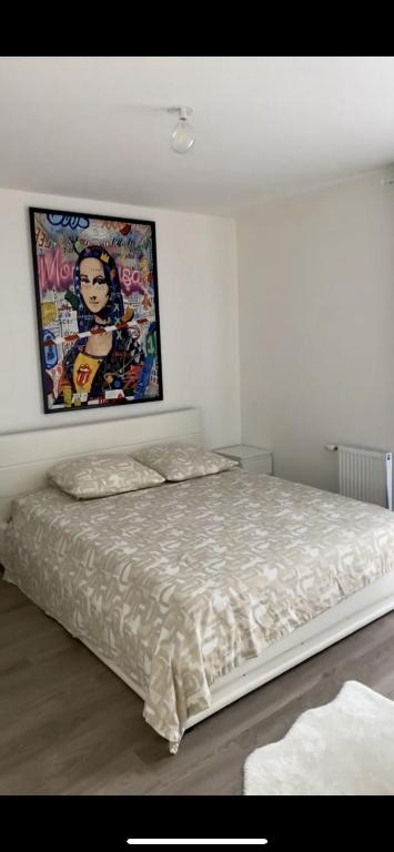 une chambre avec un lit avec un tableau sur le mur dans l'établissement Cosy Appartement, au Blanc-Mesnil