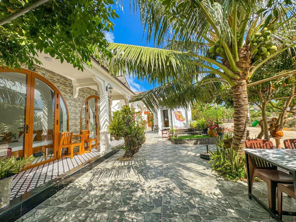a patio with a table and a palm tree at BA DŨNG VILLA COFFEE - ĐẢO PHÚ QUÝ - Bình Thuận in Cu Lao Thu