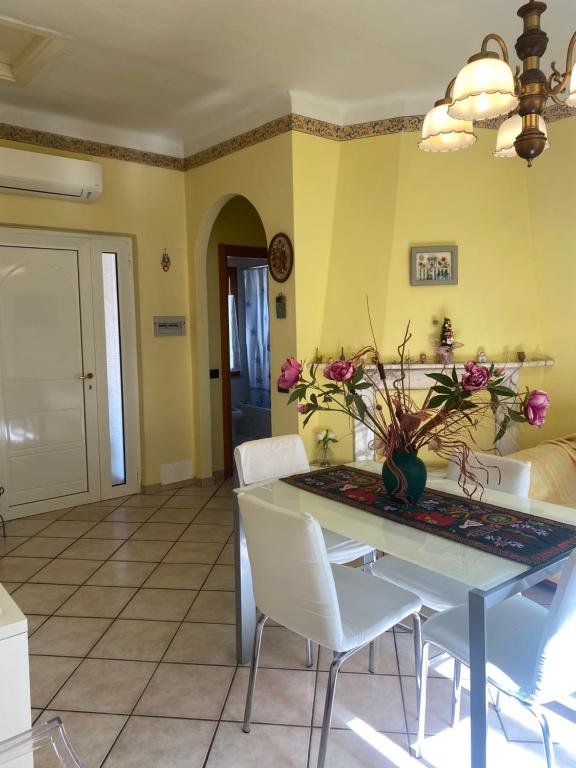 a dining room with a table and white chairs at Casa I Girasoli in Vezzano Ligure
