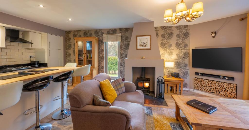 sala de estar con sofá y mesa en Abbey Holidays Loch Ness Luxury Self Catering 2 Bedroom Cottages, en Fort Augustus