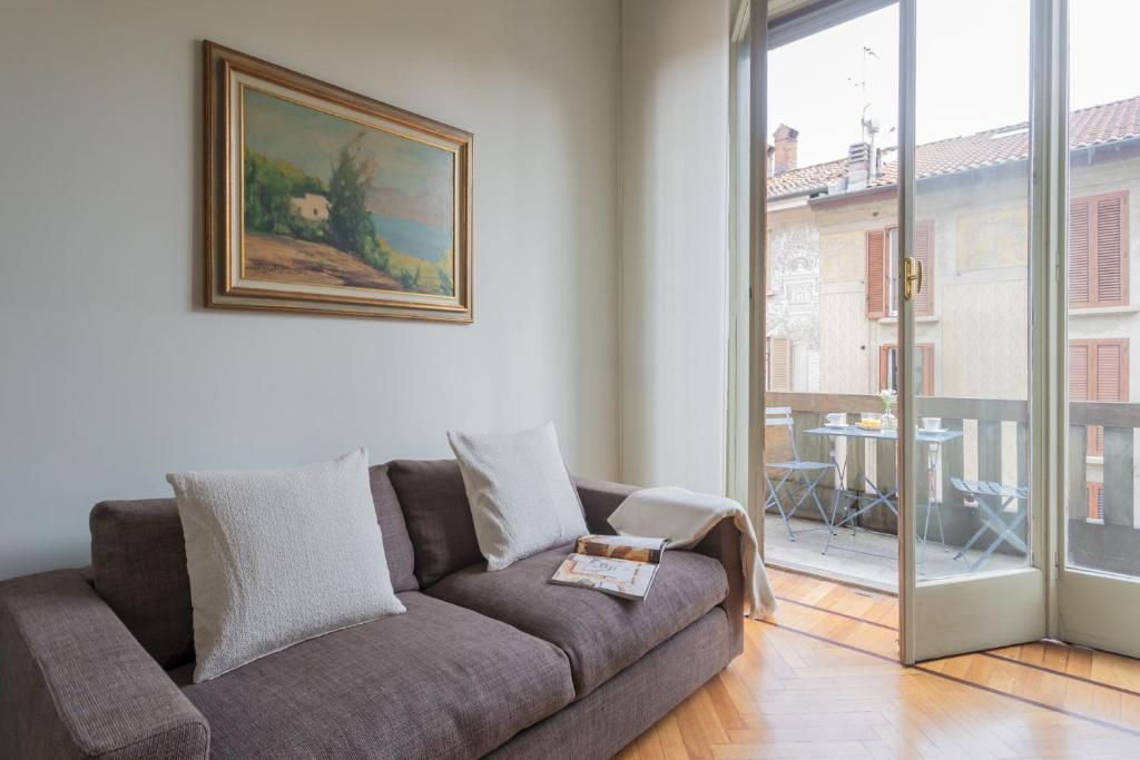 sala de estar con sofá y ventana grande en Garibaldi's Balcony by Rent All Como, en Como