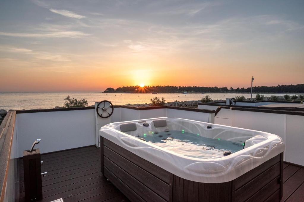un bain à remous sur une terrasse avec le coucher du soleil en arrière-plan dans l'établissement Sea Lodges Cittanova, à Novigrad