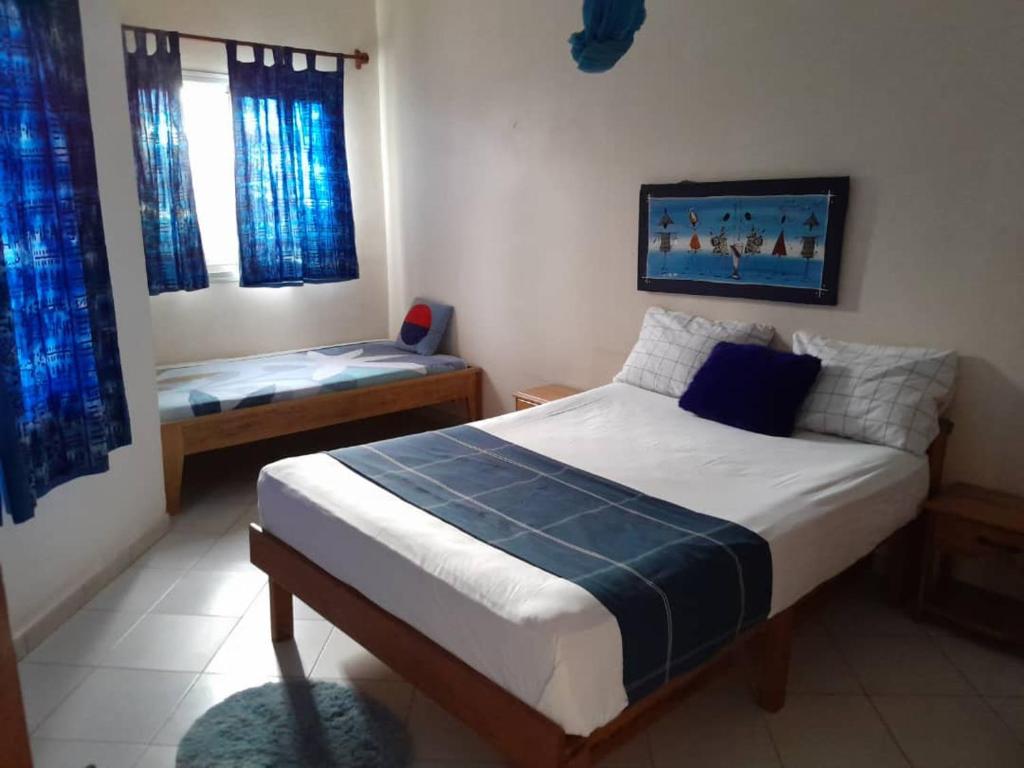 1 dormitorio con cama y banco. en Résidence Keur Fleurie Sénégal, en Rufisque