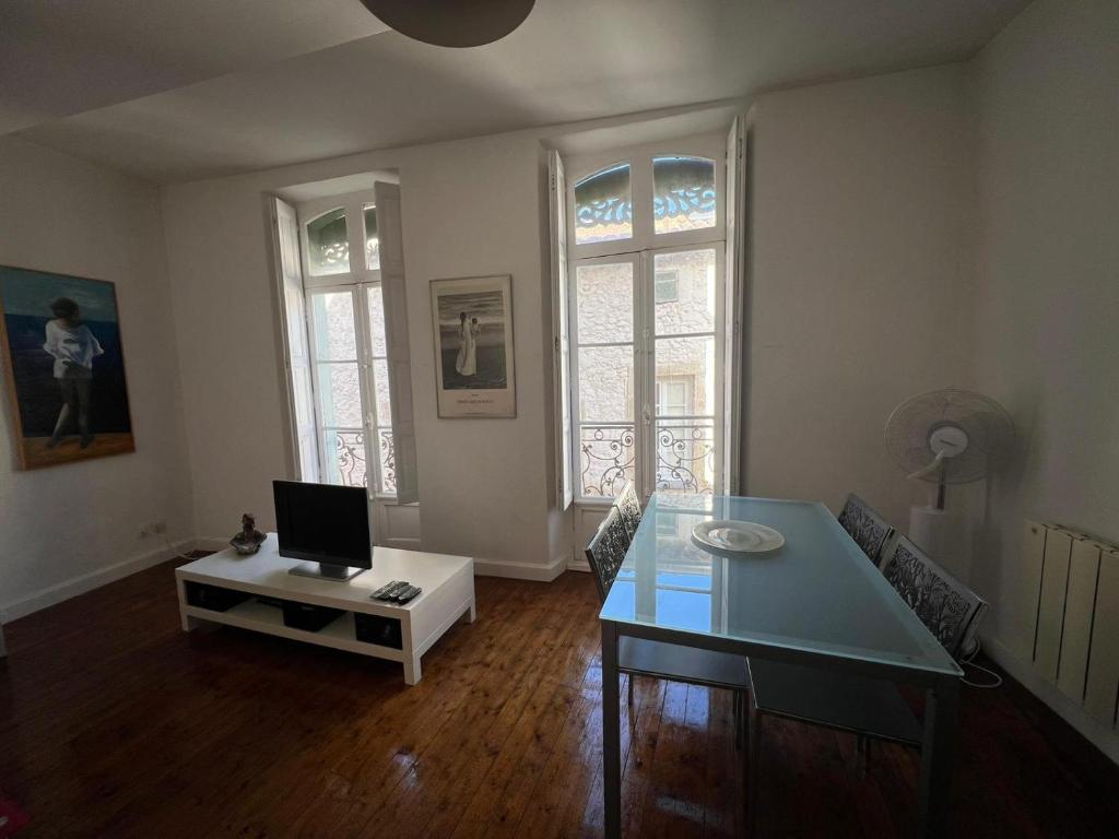 a living room with a table with a computer on it at Béziers : charmant appartement cœur de ville, WIFI in Béziers