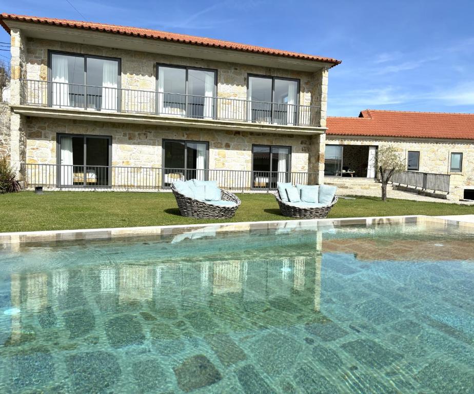 a swimming pool in front of a house at Paços do Douro, Chambre privée avec piscine in Romariz
