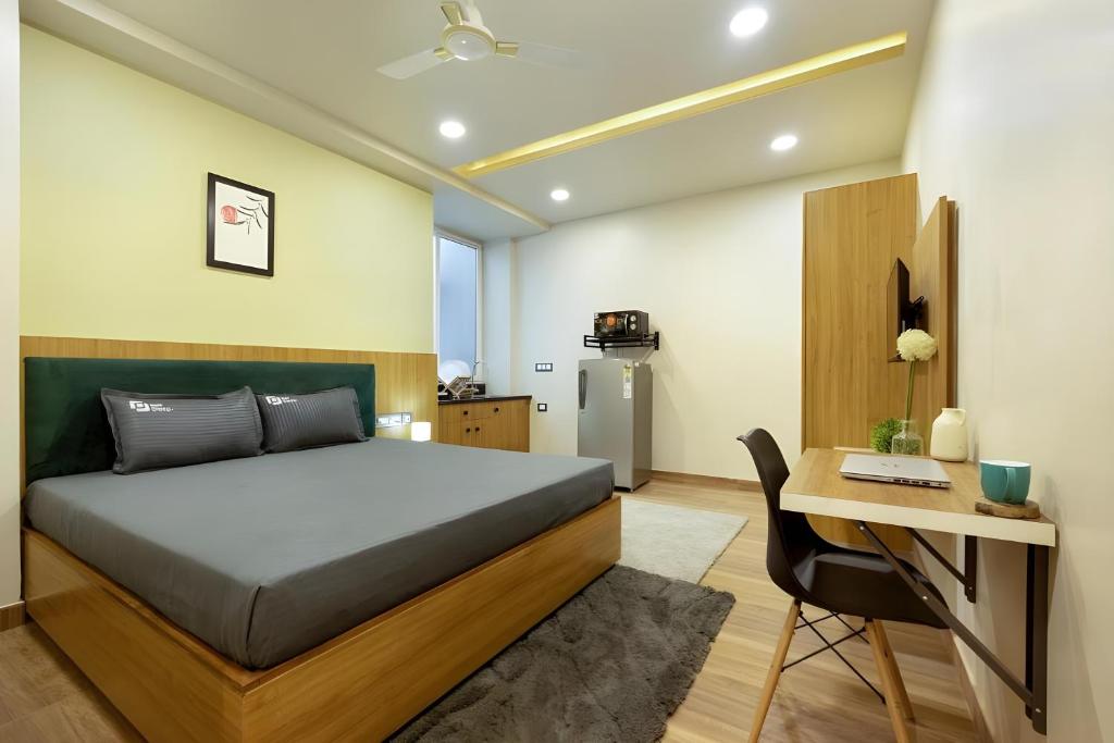 a bedroom with a bed and a desk with a computer at Wandr Lepus- Sector 39, Near Medicity Medanta in Gurgaon