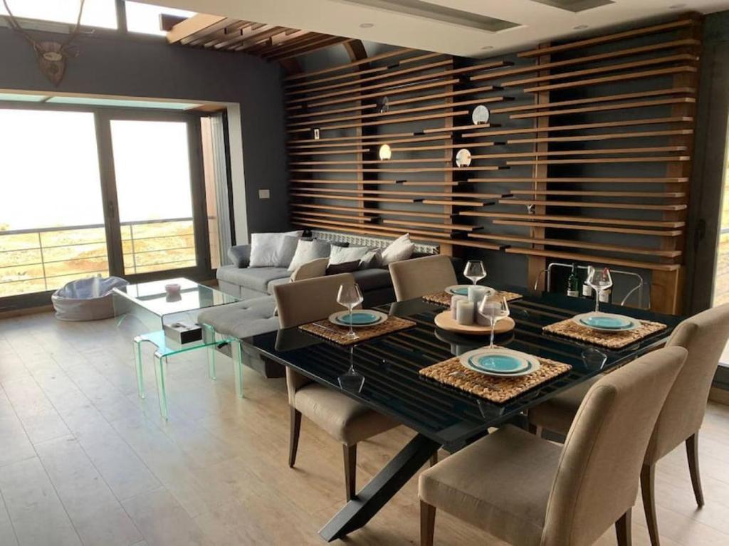 a dining room with a table and chairs and a couch at Modern 2BR Duplex in Afqā