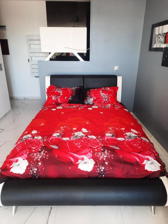 uma cama com um edredão vermelho num quarto em Esperanza em Cap d'Agde