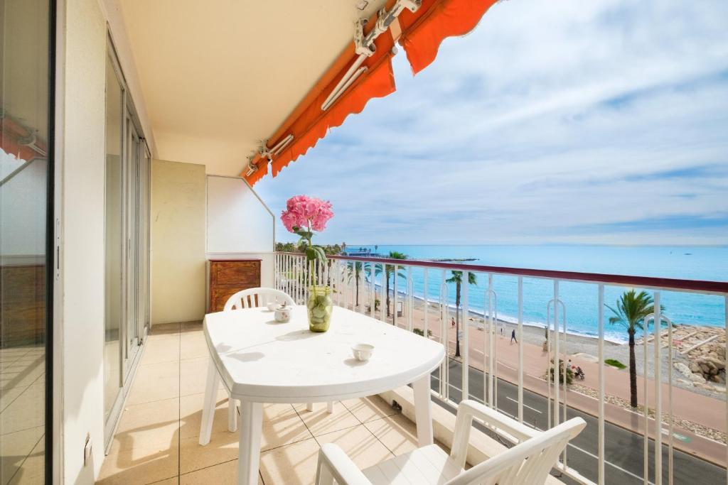a balcony with a table and a view of the ocean at Angelina -fr005 in Cagnes-sur-Mer