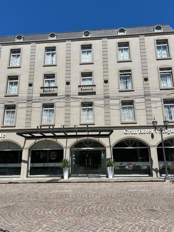 a large tan building with windows on a street at GRAN HOTEL VILLAGUAY in Villaguay