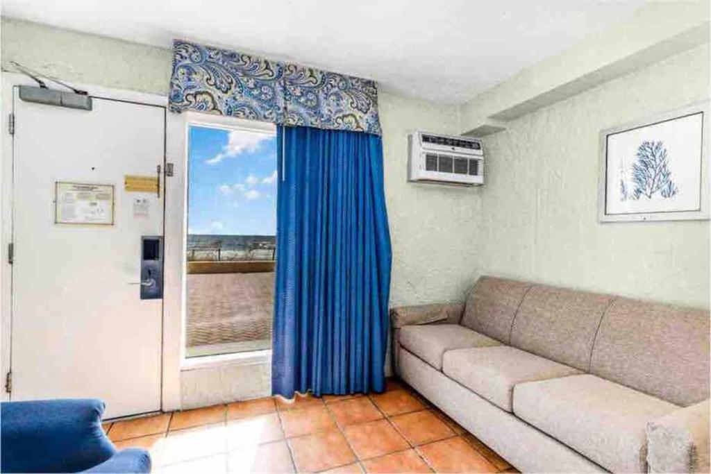 a living room with a couch and a window at Oceanfront. Ground Floor. Easily Accessible. in Myrtle Beach