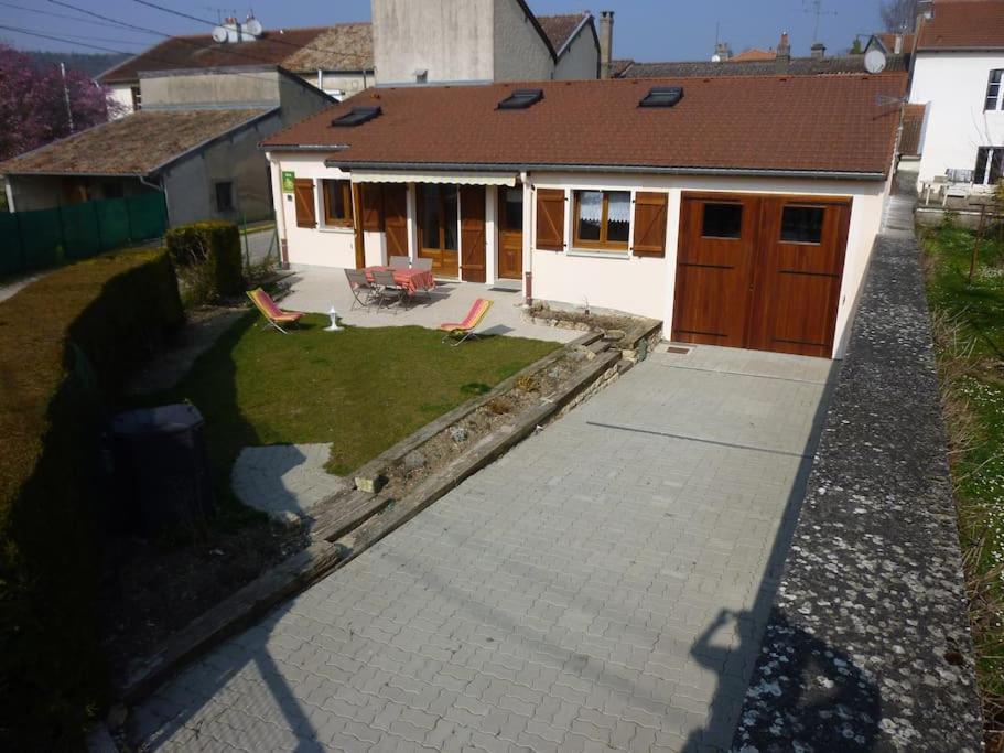 ein Haus mit einer Auffahrt, die zu einer Garage führt in der Unterkunft Le Gîte de Jules en Meuse à VIGNOT près de MADINE in Vignot