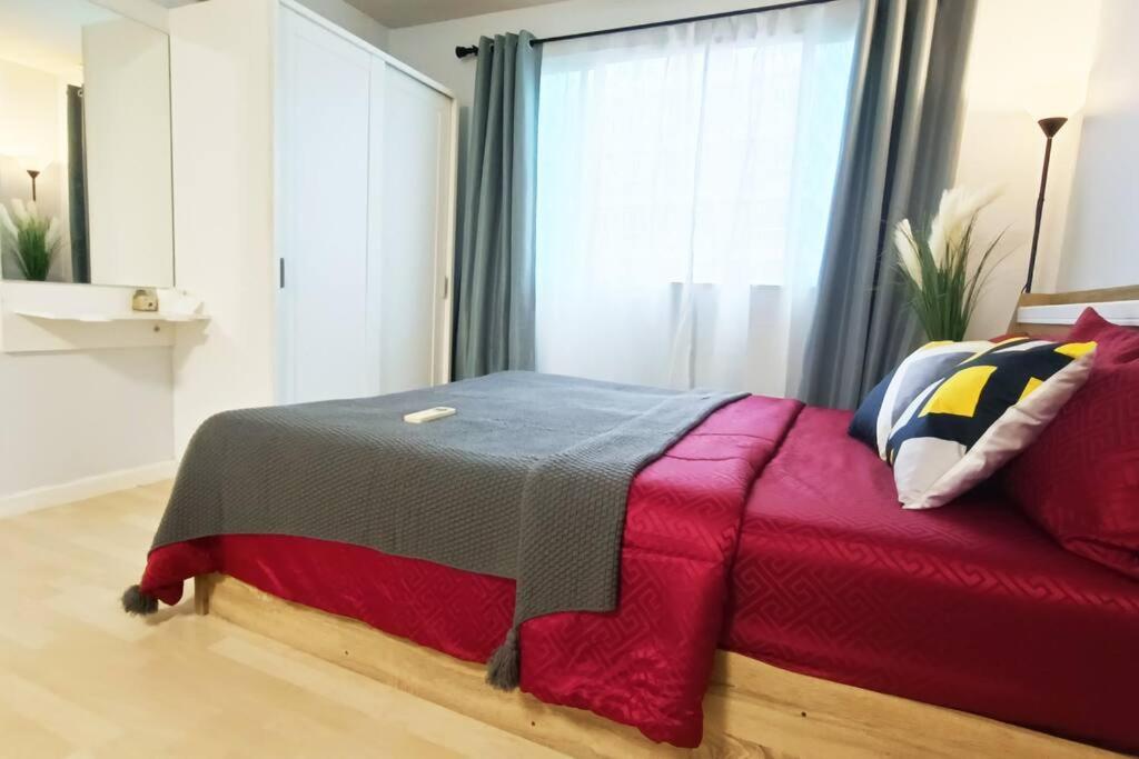 a bedroom with a red bed and a window at Cozy & Easy living Condo 65/79 in Kathu