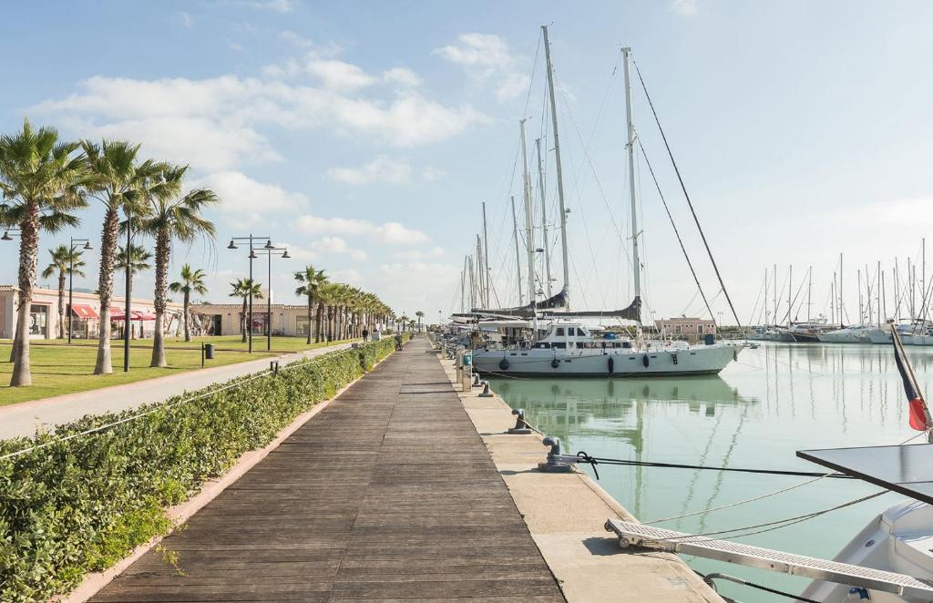 a dock with boats in a marina with palm trees at Borgo Levano in Licata