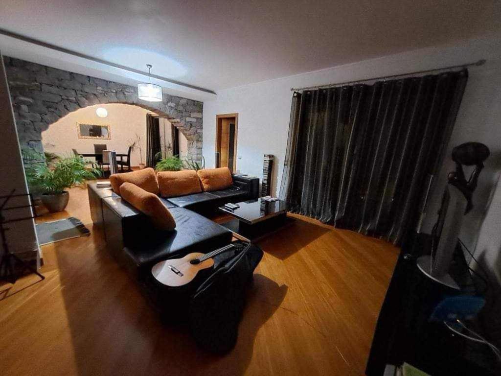 uma sala de estar com um sofá e uma guitarra em Sea View House em Ribeira Brava