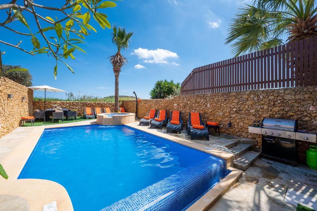 una piscina con sedie e un muro di Levecca 2 Holiday Home a Għasri
