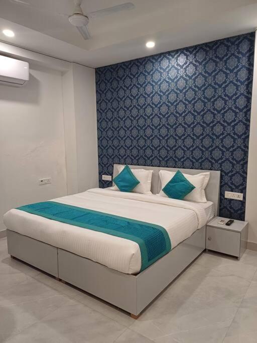 um quarto com uma cama grande e uma parede azul em Blue house sec 46 gurgaon em Gurgaon
