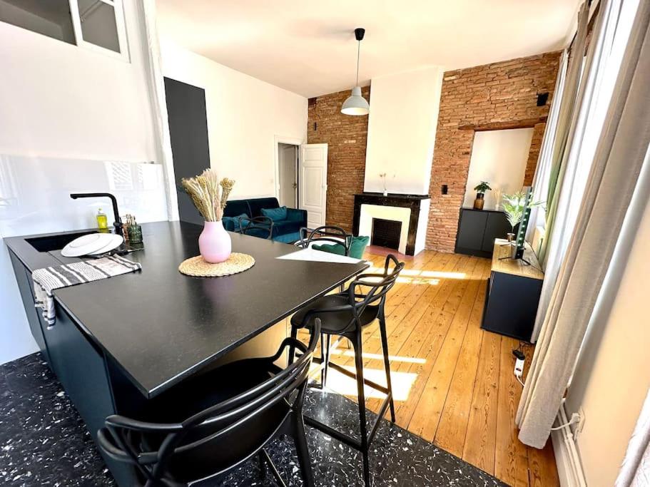 - une table et des chaises noires dans le salon dans l'établissement Appartement Standing dans hypercentre historique, à Toulouse