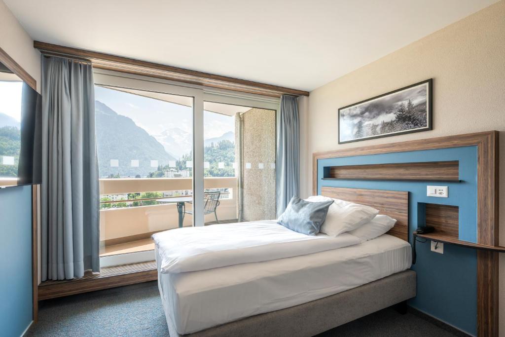 Postel nebo postele na pokoji v ubytování Hotel Metropole Interlaken