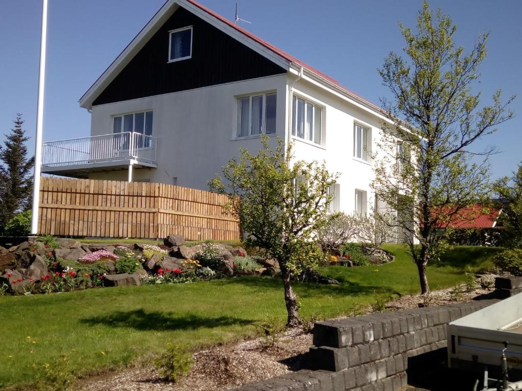 una casa blanca con techo negro en Setrið Guesthouse, en Borgarnes