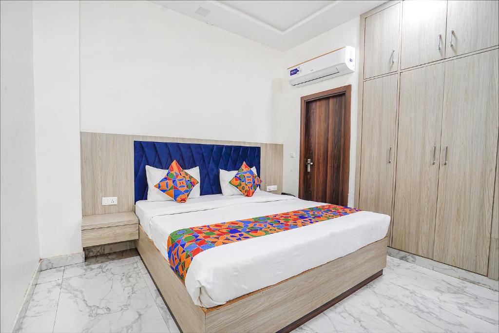 FabHotel Taj Avenue في Tājganj: غرفة نوم مع سرير كبير مع وسائد ملونة