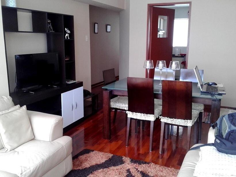 sala de estar con mesa con sillas y sofá en Kennedy Park 601 Apartment, en Lima