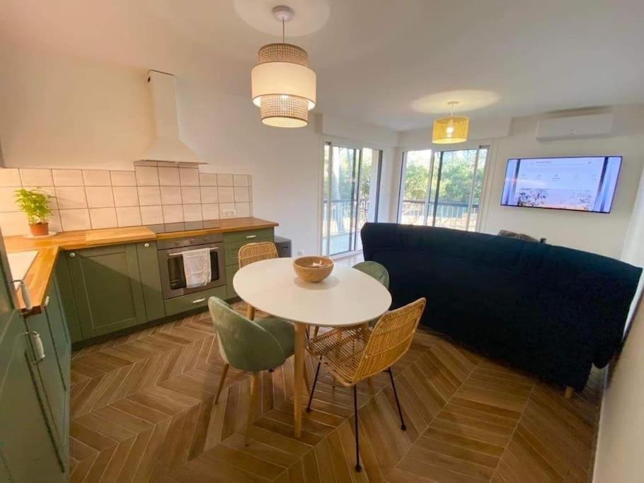 une cuisine avec une table, des chaises et un canapé dans l'établissement T2 avec clim et terrasse vue mer, les Sablettes, à La Seyne-sur-Mer