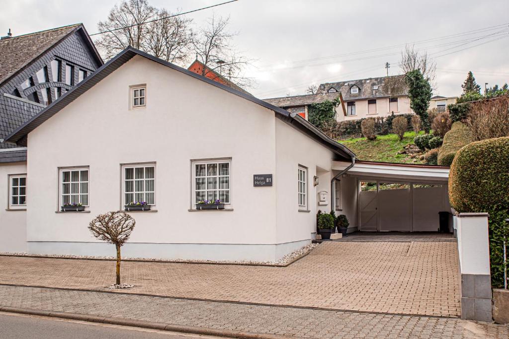 a white house with a garage on a street at Haus Helga in Idar-Oberstein