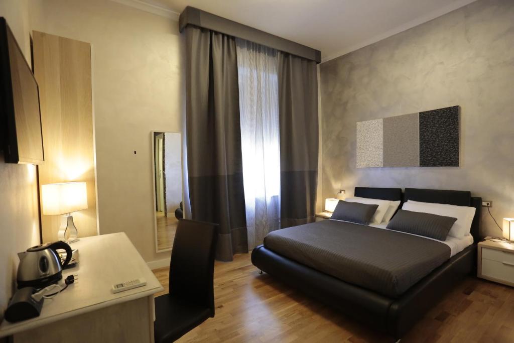 1 dormitorio con 1 cama y escritorio en una habitación en Attico Volta B&B, en Foggia