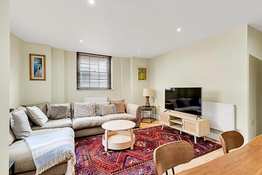 a living room with a couch and a tv at Cosy Urban Retreat in London