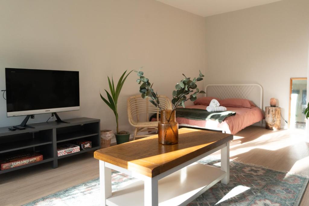 a living room with a vase of flowers on a coffee table at Studio Cabin in Belfast in Belfast