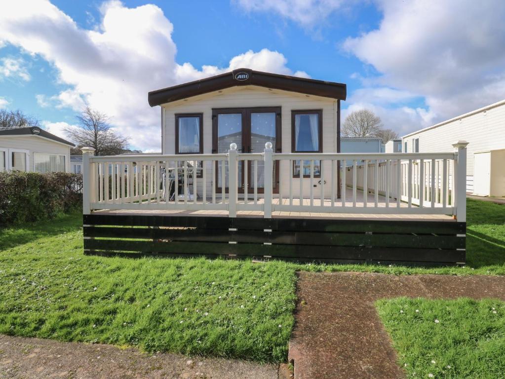 a small house with a white fence at A La Mer in Paignton