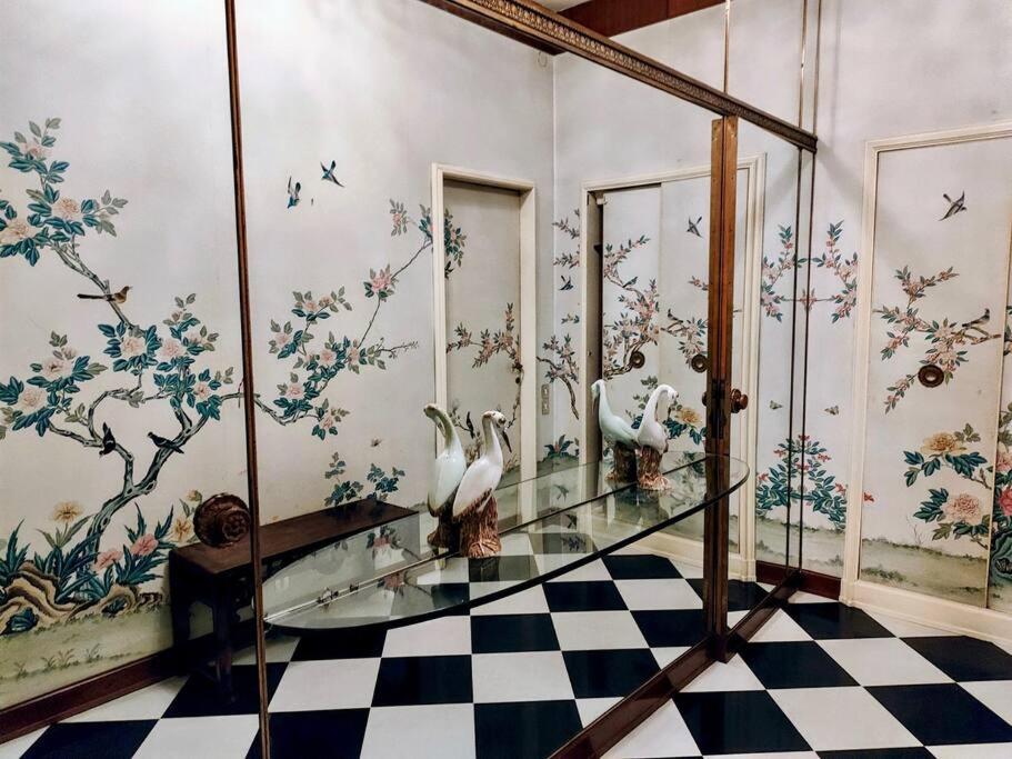 a room with a glass table with birds on the wall at Casa Valli in Reggio Emilia