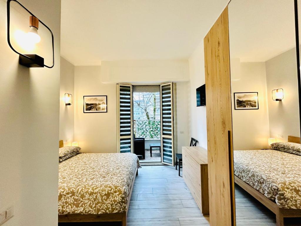 een kamer met 2 bedden en een deuropening bij Vacanze Romane in Lido di Ostia