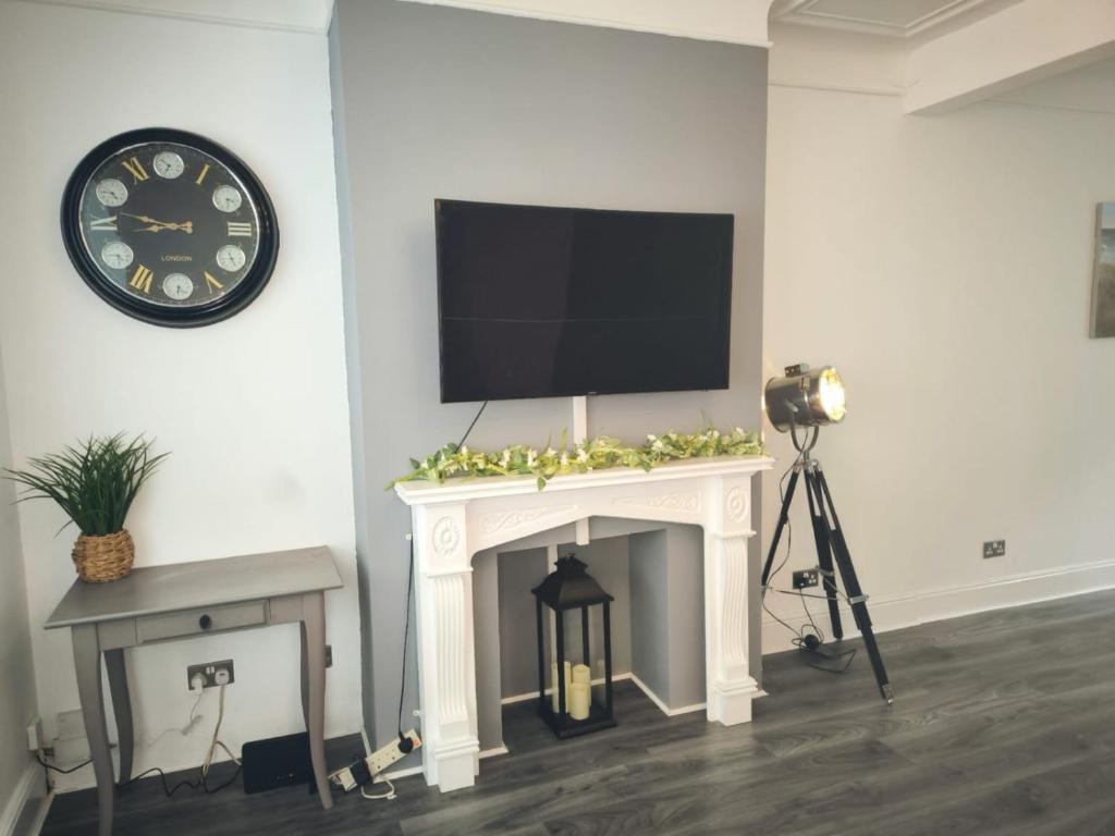 a tv on a wall above a fireplace with a camera at Spacious 3 Bedroom House with Garden for Reduced price - Limited time ONLY - in Westcliff-On-Sea