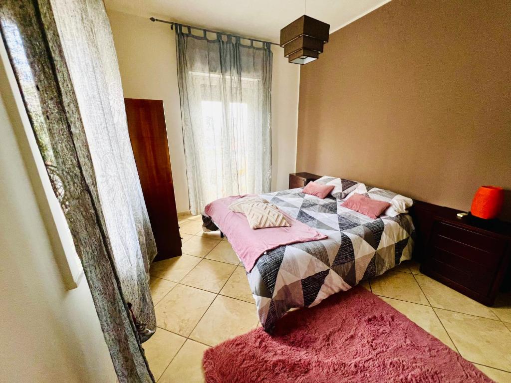 a bedroom with a bed with pink pillows on it at Villa Pina in Reggio Calabria