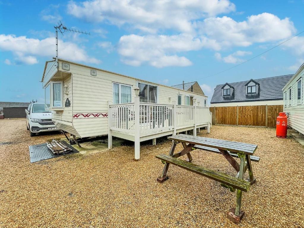 una casa con una mesa de picnic y un banco en 6 Berth Caravan In Hunstanton, Ideal For Seaside Holidays Ref 13004l, en Hunstanton