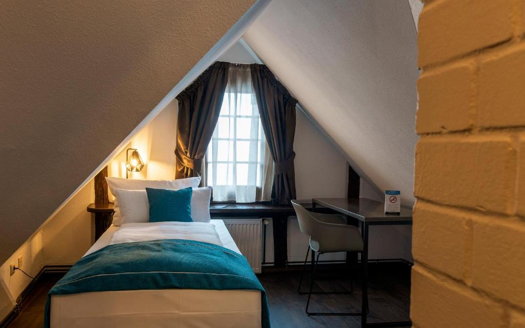 a bedroom with a bed and a desk and a window at Trip Inn Hotel Sachsenhausen in Frankfurt