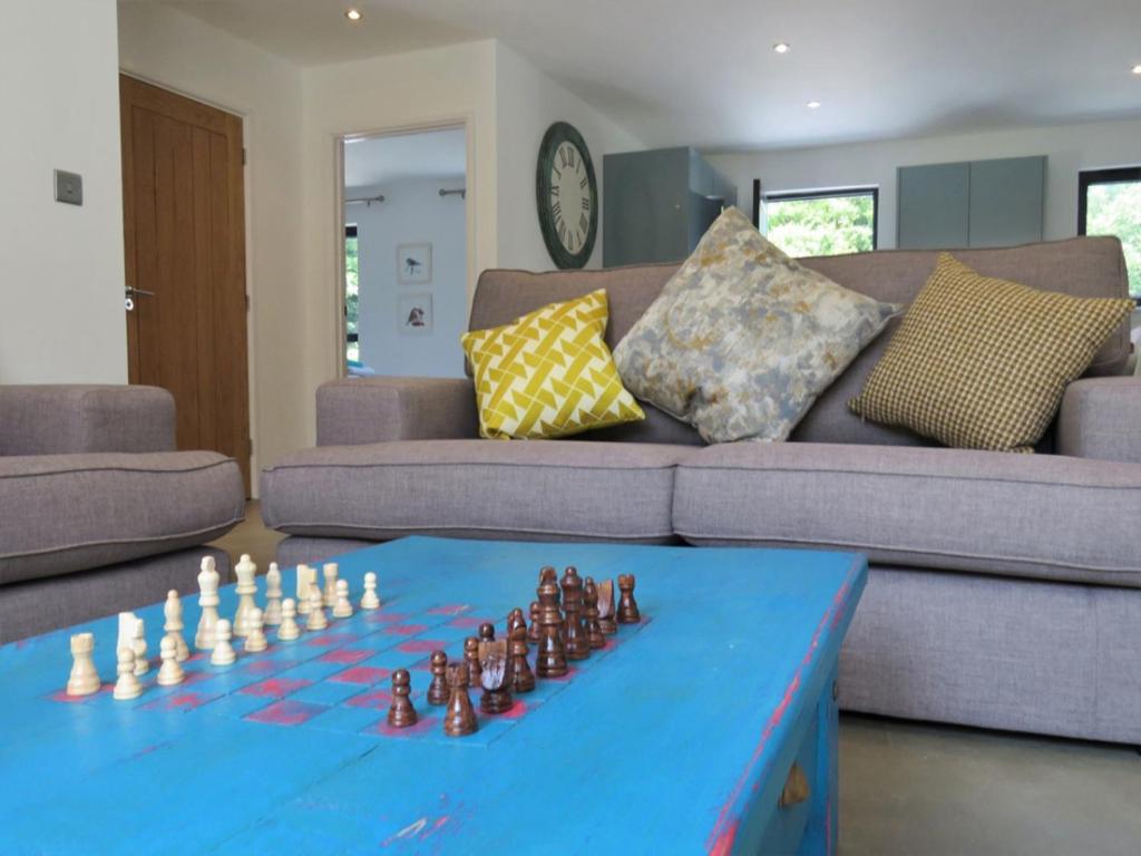 a living room with a blue table with a chess game at Ochre Cottage in Bradworthy