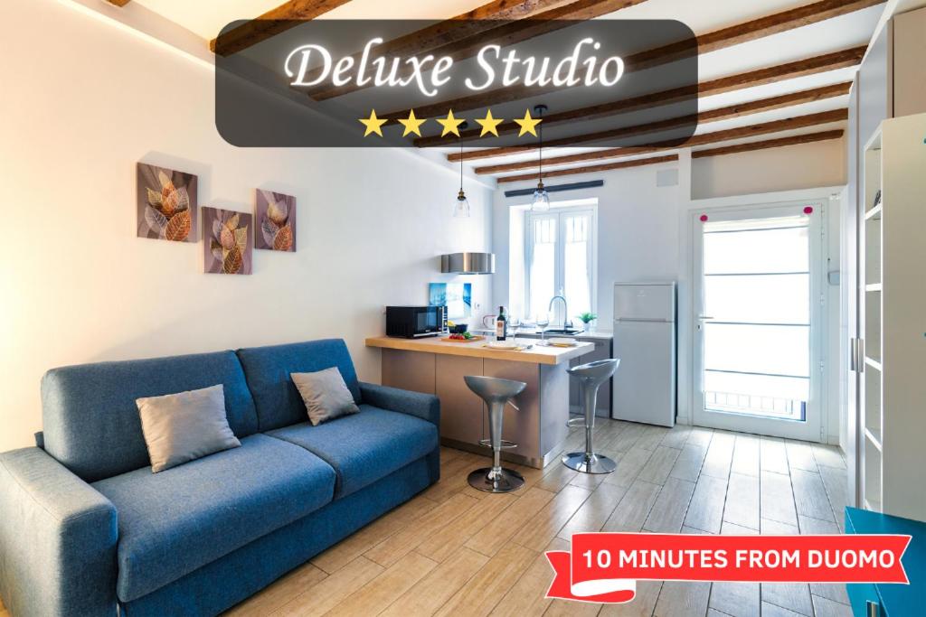 een woonkamer met een blauwe bank en een keuken bij Duomo in 10 minutes - modern close to Cadorna Station in Milaan