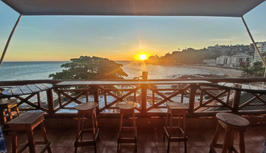 a balcony with a view of the beach at sunset at Hostel Recanto da Sereia in Salvador