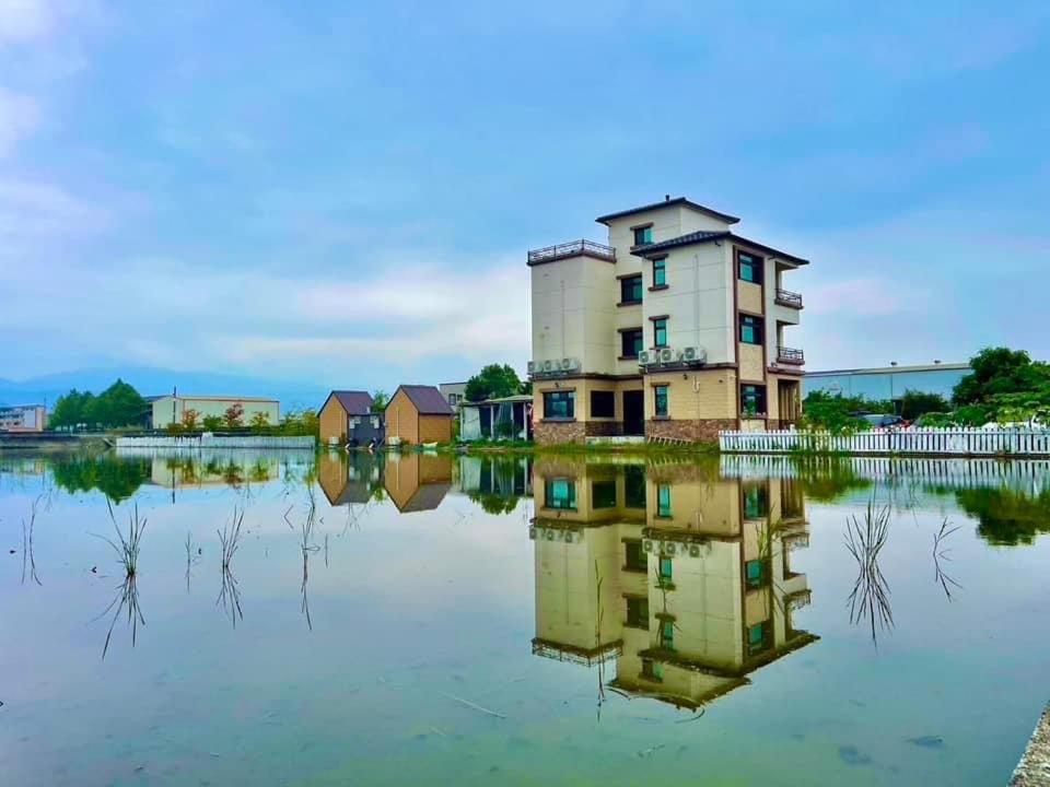 uma casa no meio de um corpo de água em 馬在對面民宿 em Yilan City