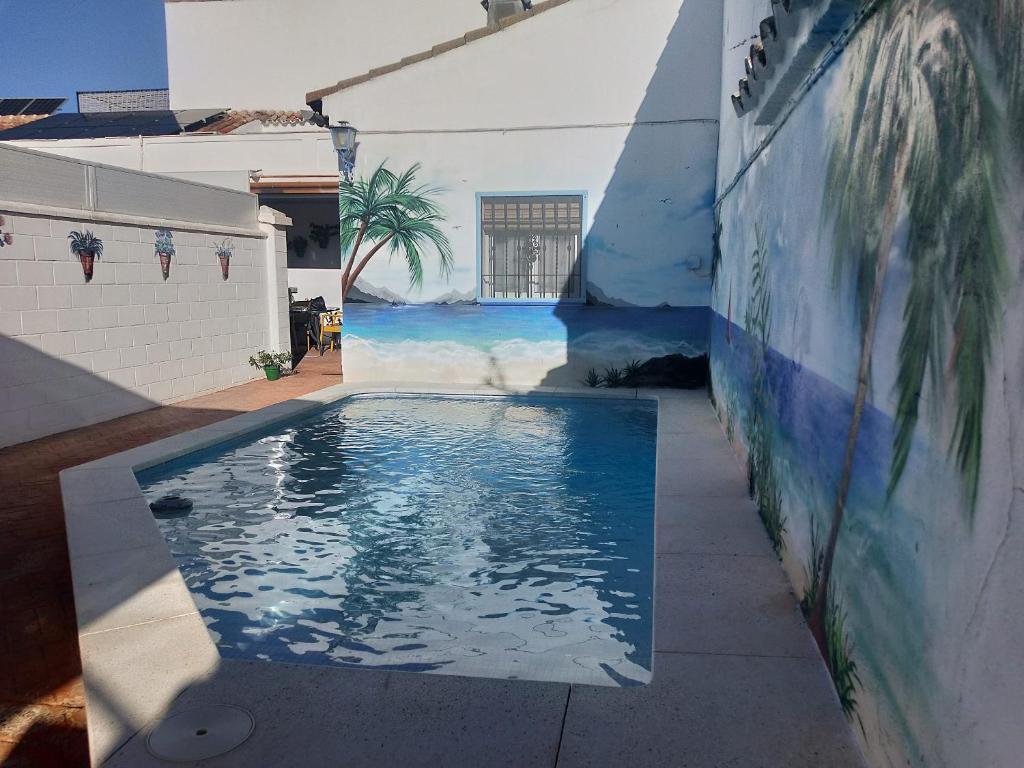 a swimming pool with a mural on the side of a building at 3 bedrooms villa with private pool furnished terrace and wifi at Encinarejo de Cordoba in Encinarejo De Córdoba