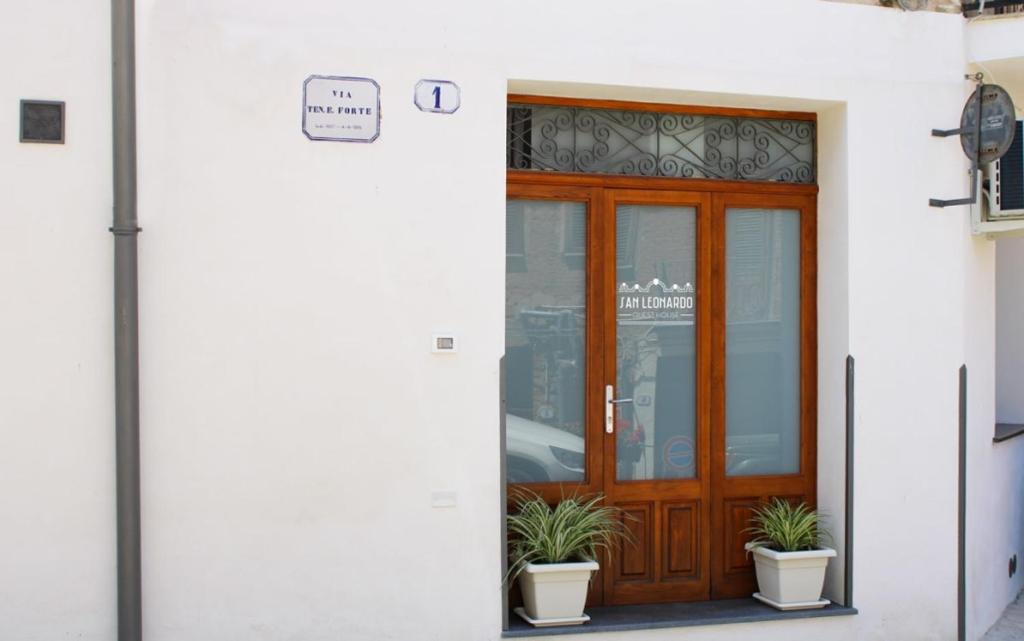 uma porta de um edifício com vasos de plantas na frente em San Leonardo Guest House em Castelbuono