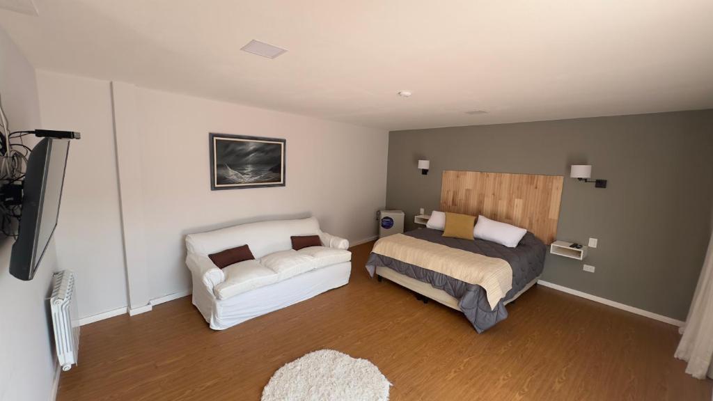1 dormitorio con 1 cama y 1 sofá en Hotel Los Aceres en Salta