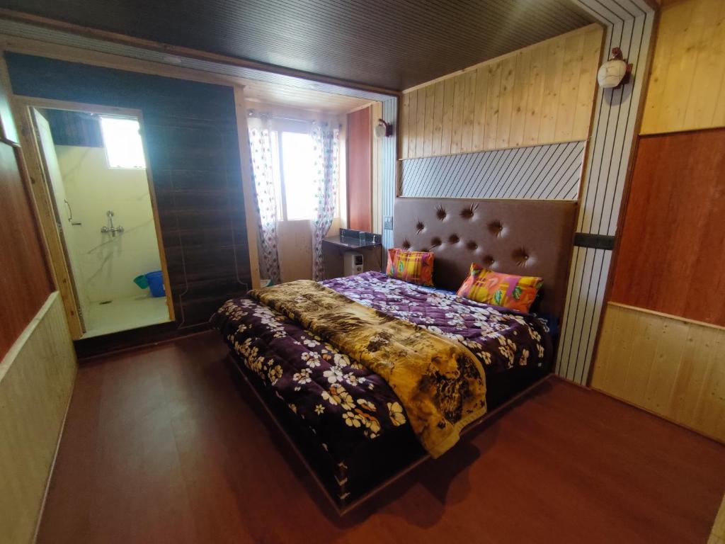 Sara Grace Cottages Cherrapunji في تشيرابونجي: غرفة نوم بسرير كبير في غرفة