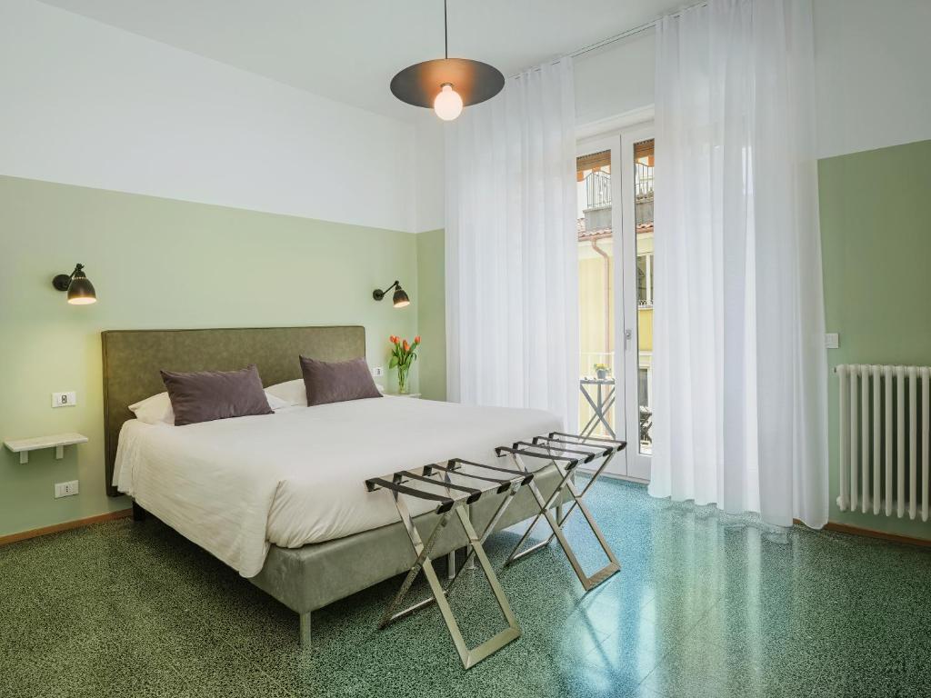 1 dormitorio con 1 cama blanca grande y 1 silla en La Casa delle Acciughe Guest House, en La Spezia