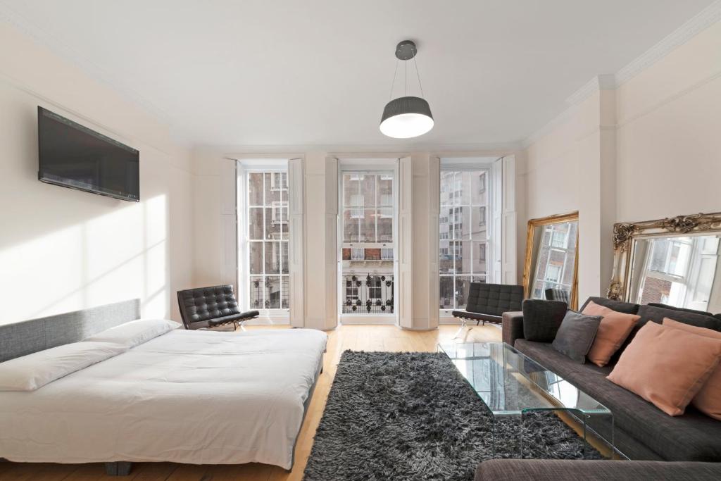 een woonkamer met een bed en een bank bij Exclusive Mayfair Apartment Suite in Londen